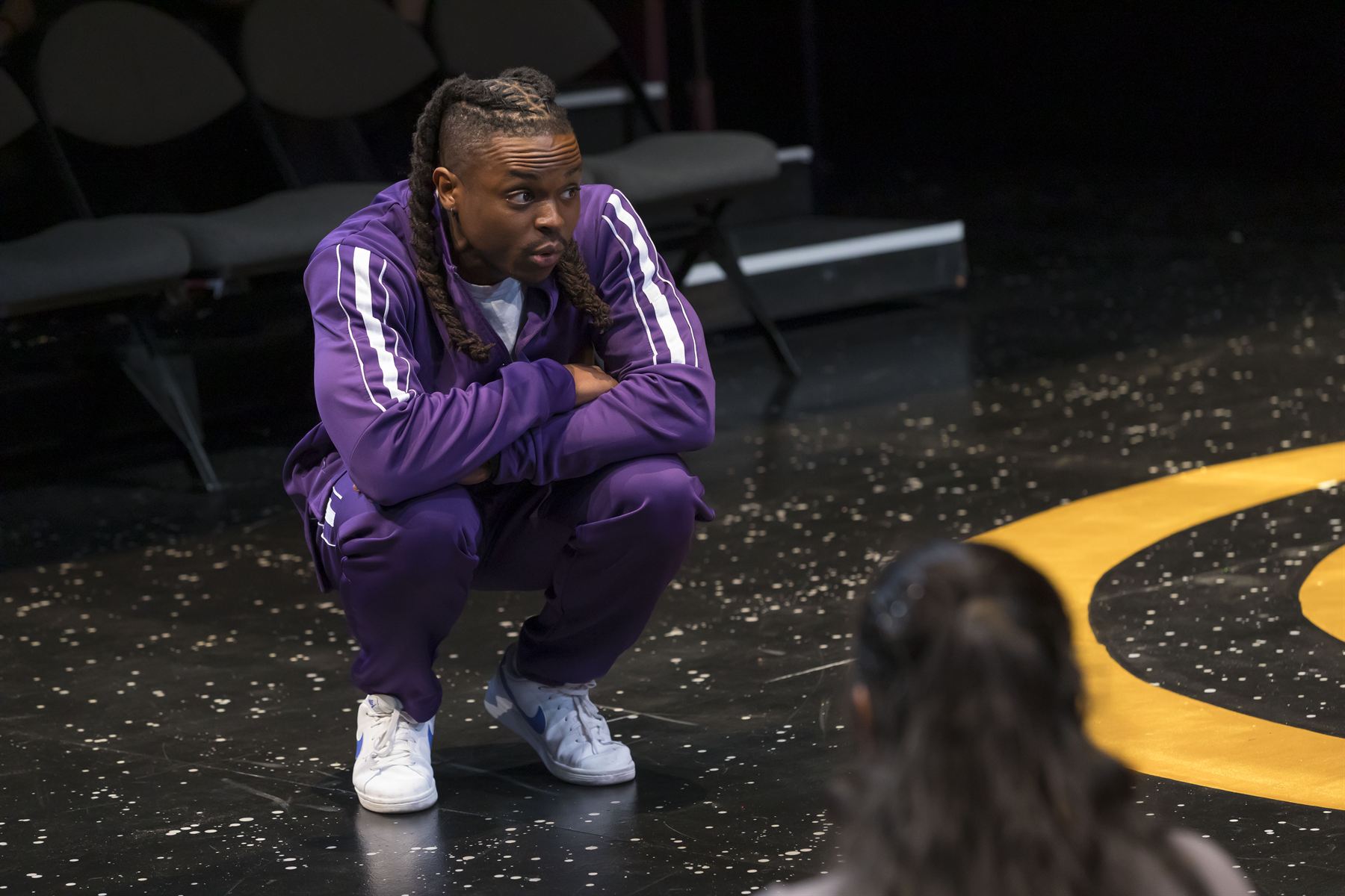 Dance Teacher Pat crouched low, looking back over one shoulder