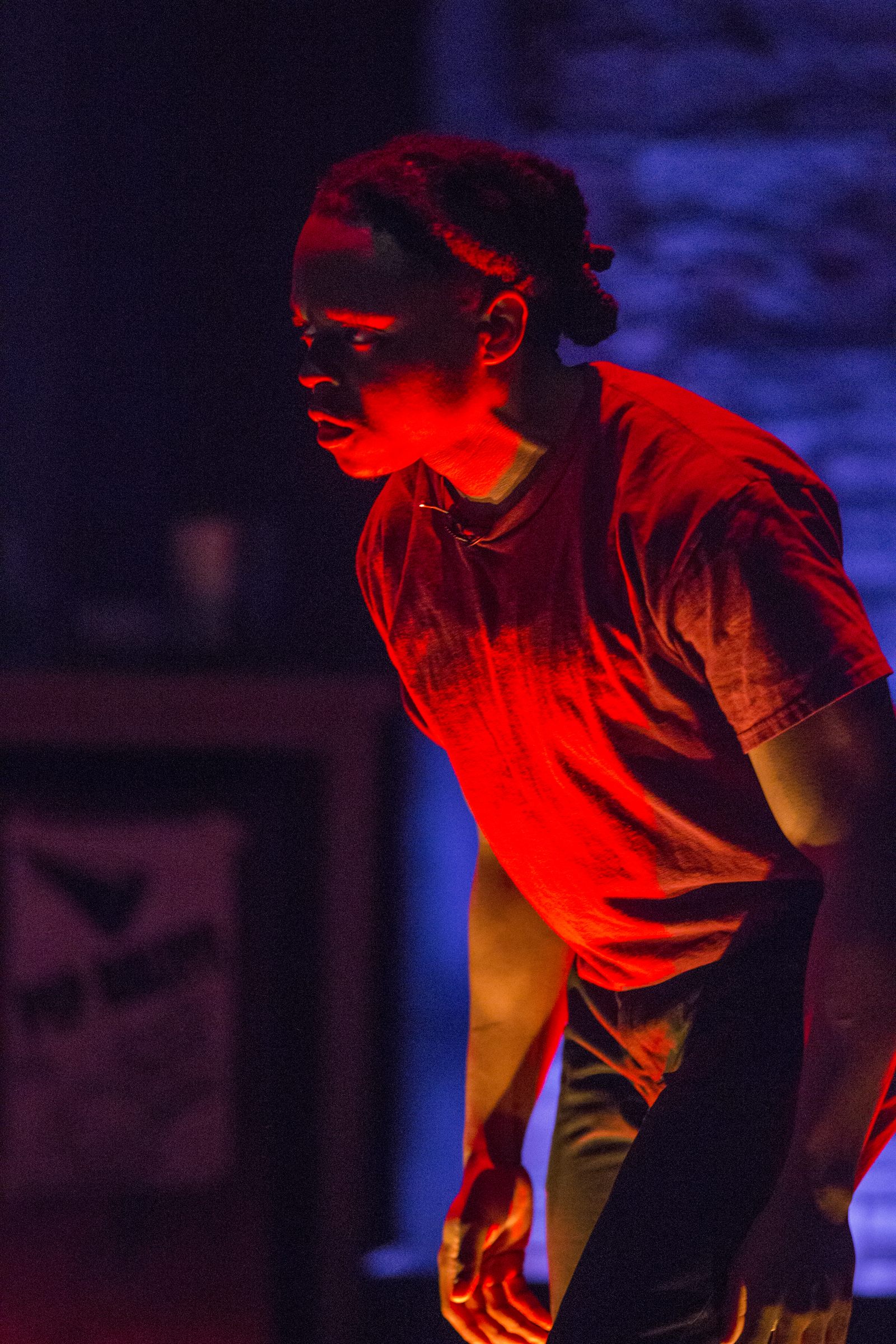 Brian Alexander Davis on stage in Pipeline, lit in deep red light