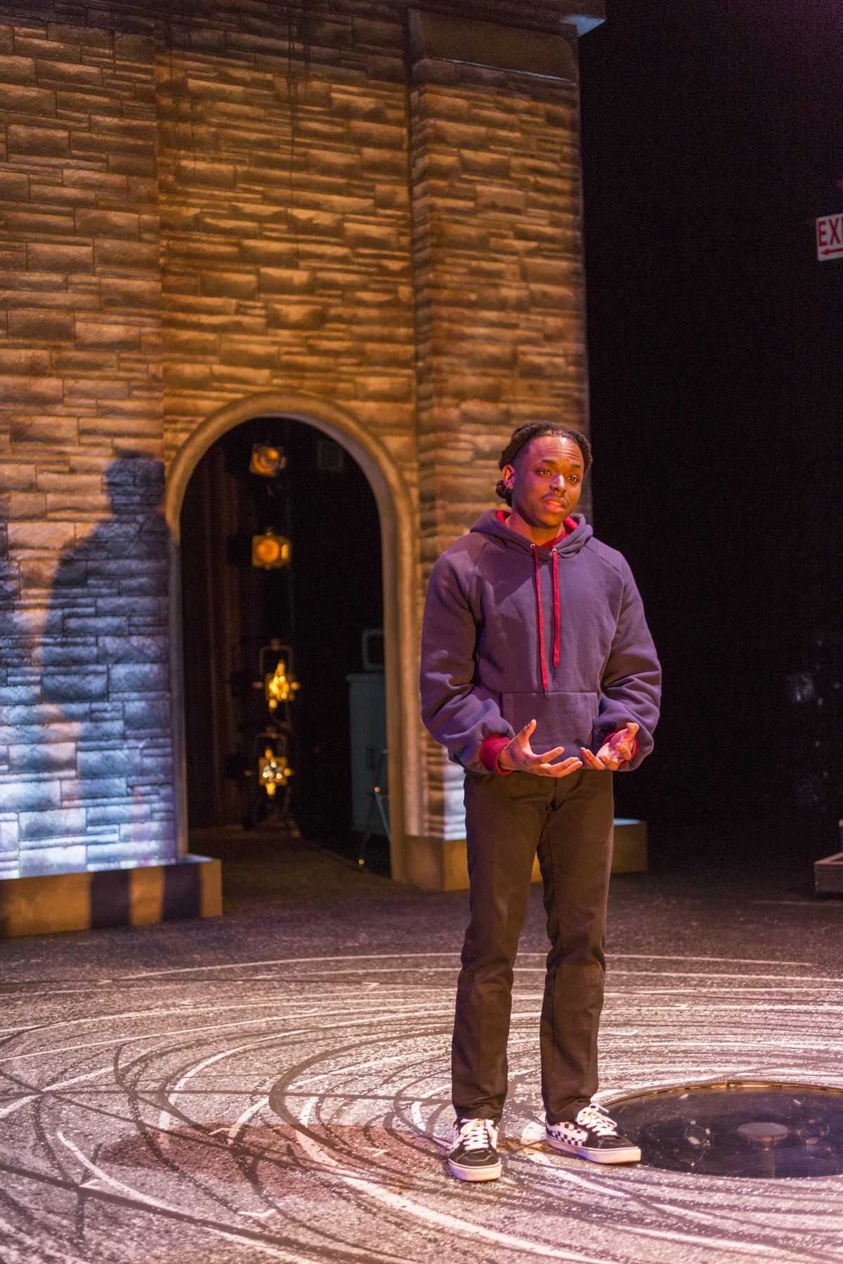 Brian Alexander Davis on stage as Omari in Pipeline, standing in warm side light