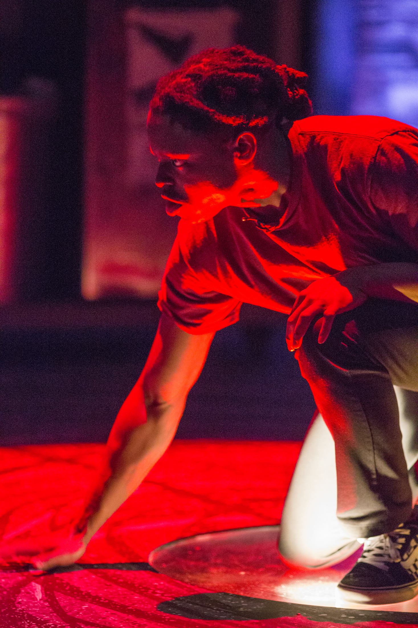 Brian Alexander Davis on stage in Pipeline, lit in deep red light
