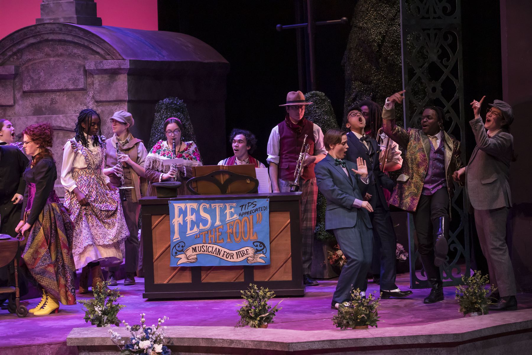 The full company gathers around Feste the Fool's musician booth